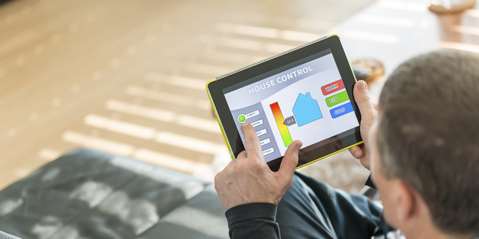 Man using digital tablet for remote house control