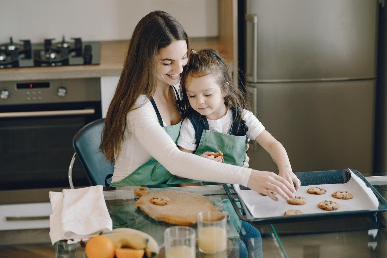 Babysitter and kid making cookies