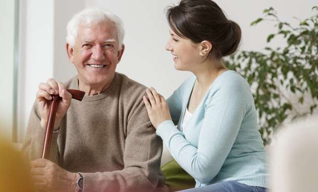 A granddaughter caring for her elderly grandfather in his home.