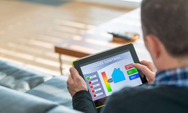A homeowner using a tablet to control his home after preparing his home for home automation.