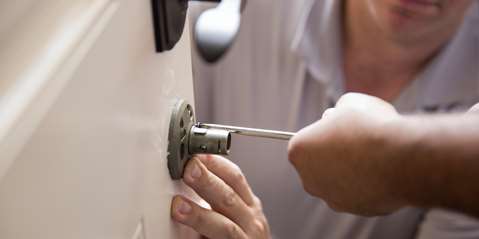 Man installing door lock with screwdriver