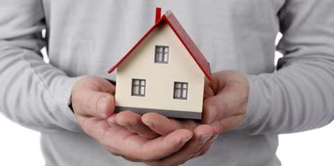 Man holding tiny house