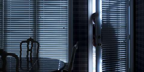 Burglar Breaking In To Home At Night Through Back Door