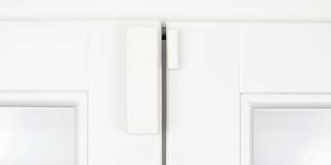 Wireless alarm sensor for window and door on white wood