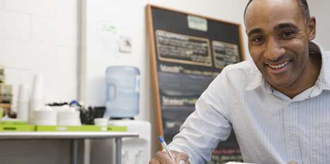 Man doing accounts in cafe