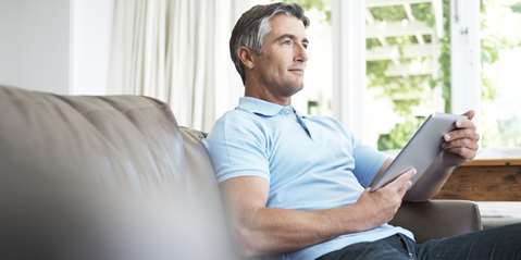 handsome mature man relaxing with his digital tablet at home